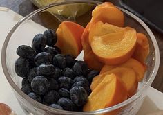 a glass bowl filled with blueberries and orange slices