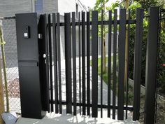 a black gate is open in front of a house