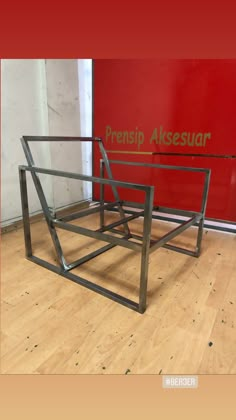 a metal frame sitting on top of a hard wood floor next to a red wall