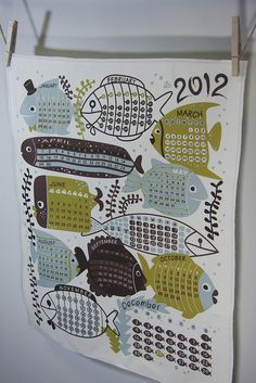 a tea towel hanging from a clothes line with fish on it's side and the year 2012