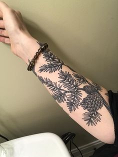 a person with a pine cone tattoo on their arm