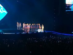 a group of people standing on top of a stage in front of a large crowd