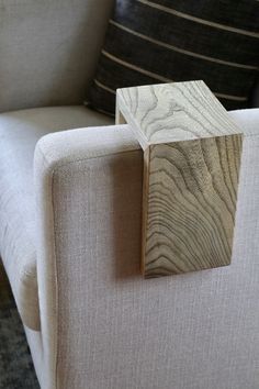 a wooden block sitting on top of a white couch