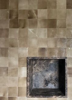 a bathroom with a toilet and tiled walls