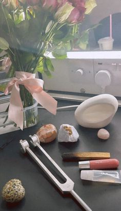 a vase filled with flowers sitting on top of a table next to other items and tools