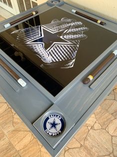 a large metal box with an army emblem on the front and side, sitting on top of a tile floor