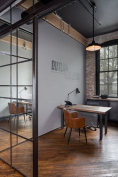 an office with a desk and chair in the corner, next to a large window