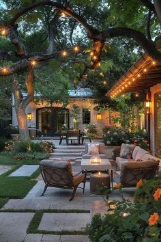 an outdoor living area with patio furniture and string lights strung over the seating areas, surrounded by greenery