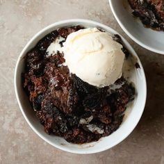 two white bowls filled with dessert and ice cream on top of a marble countertop