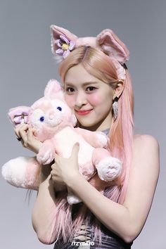 a girl with pink hair holding two stuffed animals