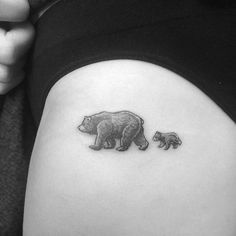 a black and white photo of a bear and cub tattoo on the side of a woman's stomach