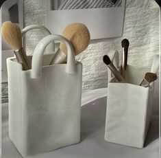 two white bags with makeup brushes in them