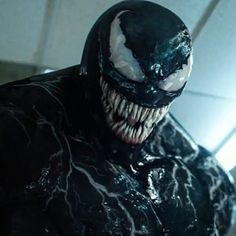 a close up of a person wearing a black suit with white teeth and fangs on his face