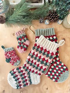 crocheted christmas stockings and stocking ornaments on a table