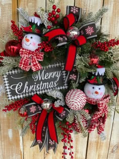 a christmas wreath with two snowmen on it