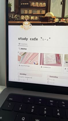 an open laptop computer sitting on top of a white desk next to a cup of coffee