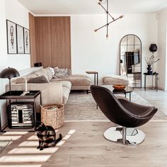 a living room filled with furniture and a cat sitting on the floor next to it