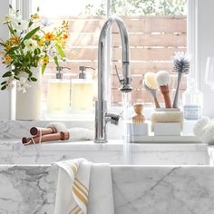 a kitchen sink with marble counter tops and white towels