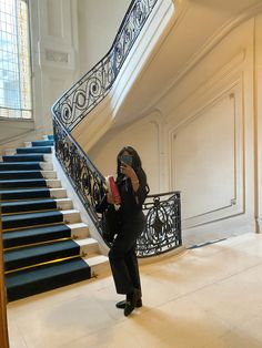 a woman standing in front of a staircase taking a photo