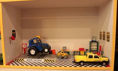 toy cars and trucks in a playroom with checkered flooring on the walls