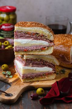 two sandwiches stacked on top of each other next to olives