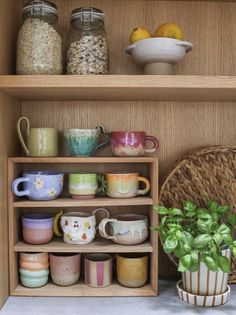 a wooden shelf filled with lots of cups and bowls