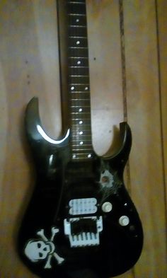 a black guitar with skulls and bones on it