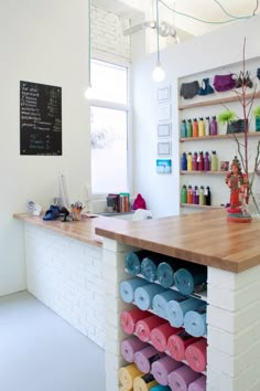 a counter top with lots of different colored items on it in a room next to a window