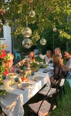 a group of people sitting around a table outside