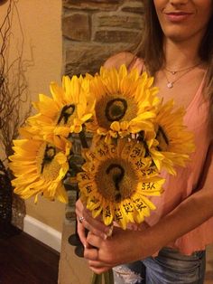 a woman holding a bouquet of sunflowers in her hands