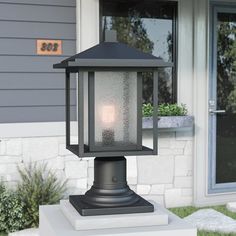 a light that is sitting on top of a white block in front of a house