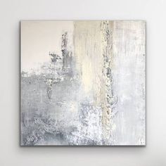 an abstract painting with white and grey colors on the wall above a chair in a living room