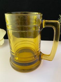 a yellow glass mug sitting on top of a table