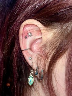 a close up of a person with ear piercings on their ears and behind the ear