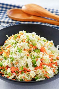 a black bowl filled with coleslaw and carrots