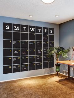 a room with a desk and a large calendar on the wall