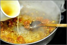 someone is pouring sauce into a pot full of food