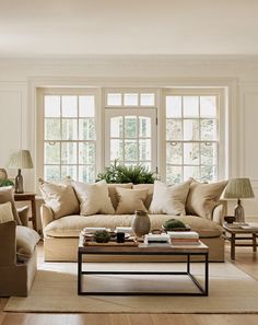 a living room filled with furniture and lots of window sill space next to a coffee table