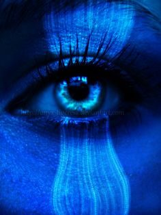 a woman's face painted in blue with the image of a tear coming out of her eye