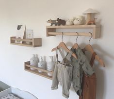 the baby's clothes are hanging on wooden shelves