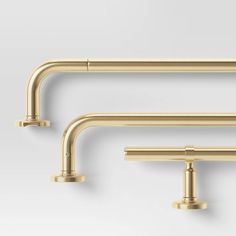 two gold faucets are shown against a white background, one is in the shape of a pipe