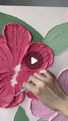 a person is painting a flower with pink and green paint on the paper flowers that have been cut out