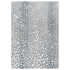 an animal print rug with white and black spots on grey ground, in front of a white background