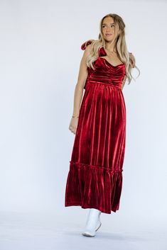 Indulge in luxury and make a statement this holiday season with our Cindy Velvet Dress in stunning red. Wrapped in soft velvet, this maxi dress exudes elegance and is adorned with a delicate bow detail. Dress to impress in this must-have piece for any special occasion. Product Materials: 95% Polyester, 5% Spandex Model Measurements: Hips 36” Waist 25” Bust: 31”, Height 5’5.5, wearing a size small Blessing Dress, Temple Dress, Red Shirt Dress, Boho Style Dresses, Bow Detail Dress, Red Shirt, Overall Dress, Romper Pants, Smock Dress