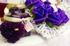 purple flowers are sitting on a table next to a jar