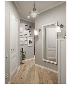 an empty hallway with pictures on the wall and wood flooring in front of it