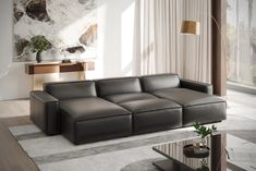 a modern living room with grey leather couches and coffee table in front of a large window