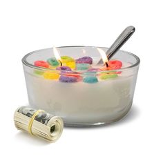 a bowl filled with gummy bears next to a roll of money and a lighter