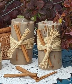 three candles are wrapped in twine and tied with twine, next to some cinnamon sticks