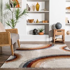 a living room with white walls and wooden flooring is furnished with an area rug